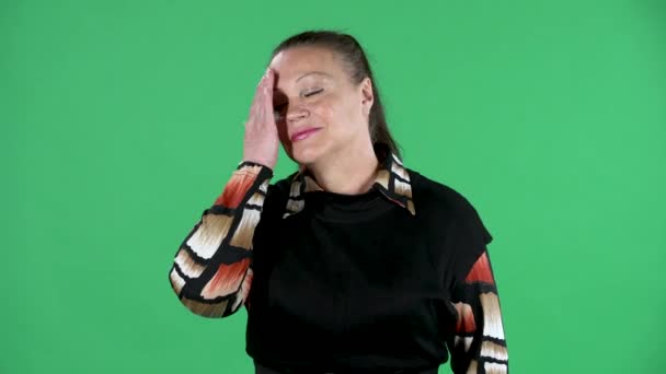 Retrato de anciana mirando a la cámara y haciendo un gesto de rostro. Morena abuelita en vestido negro en pantalla verde en el estudio. De cerca.. — Vídeos de Stock