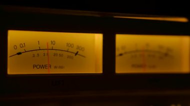 Sarı, eski bir analog radyodaki gösterge panelini kontrol ediyor. Elektronik ses cihazında aşırı derecede yükselen ve alçalan gösterge iğnesi okuma seviyesi. Kapatın. Yavaş çekim.