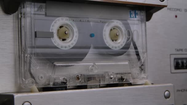 Starý ošuntělý kompaktní kazeťák se točí v magnetofonu. Detailní makro záběr archivního magnetofonu. Poslouchám nostalgickou hudbu z 90. let. Zavřít. Zpomalený pohyb. — Stock video