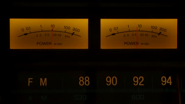 Panel de mandos amarillo en una vieja radio analógica. Extremo primer plano del indicador de movimiento de la aguja nivel de lectura que sube y baja en el dispositivo de audio de sonido electrónico vintage. De cerca. Movimiento lento. — Vídeos de Stock