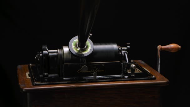 Классический фонограф Эдисона играет музыку через рог на фоне черной студии. Ретро-винтажная машина для воспроизведения звуков, слушая музыку. Закрывай. Медленное движение. — стоковое видео