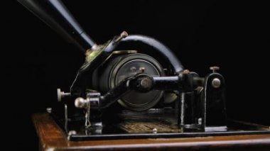 Macro, klasik Edison Phonograph 'ın siyah bir stüdyo arka planında müzik çaldığını detaylı bir şekilde çekti. Müzik dinlerken ses üretmek için eski model bir makine. Yan görüş. Kapatın. Yavaş çekim.