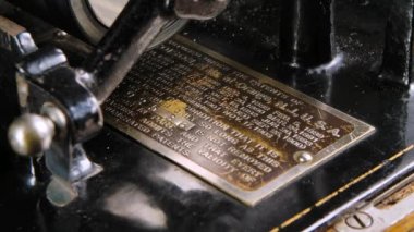 Makro, Edison retro fonografının seri numarasıyla metal patentlerini detaylı olarak inceledi. Müzik dinlerken ses üreten klasik bir makine. Kapatın. Yavaş çekim.