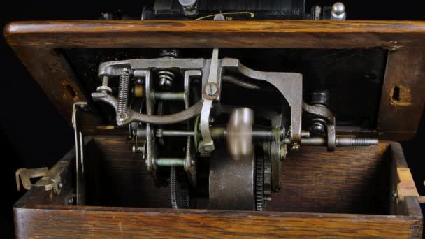 Macro detailed shot of the internal mechanisms of a classic phonograph on a black studio background. Rotating parts of a retro musical instrument. Close up. Slow motion. — Stock Video