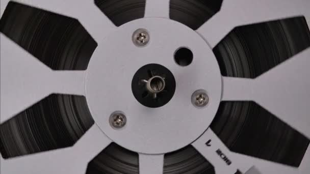 Reel to reel tape recorder playing loop. Rotating vintage music player close up. Retro tape. Spinning reels metallic color. Front view. — Stock Video