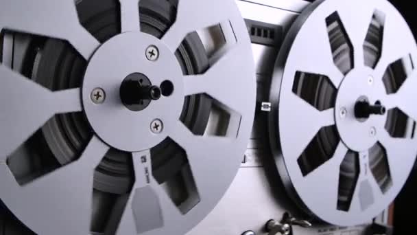 Spinning Takeup Spule eines alten analogen Reel-to-Reel Audio-Tonbandgeräts. Form eines Magnetbandaudiorecorders, bei dem das Aufnahmemedium auf einer Rolle gehalten wird, die sich nicht in einer Kassette befindet. Nahaufnahme. — Stockvideo