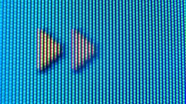 Eski bir analog televizyon ekranının pikselleri. Kırmızı, mavi ve yeşil noktalar ekranda hareket eden bir ok oluşturuyor. Makro. Kapat..