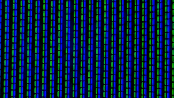 Werkende pixels in het scherm kleuren-tv, met een video afspelen close-up. Blauwe, groene en rode pixels flikkeren tegen een zwarte achtergrond. Blauwe wijting. — Stockvideo