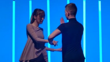 Parlak neon lambaların üzerinde partneriyle rumba yapan tutkulu genç bir kadın. Ağır çekimde hareket eden iki güzel dansçı. Kapat..