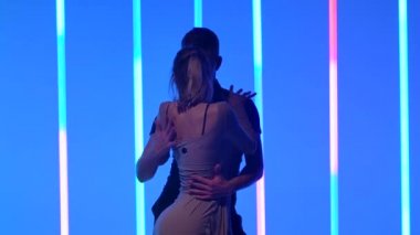 Güzel beyaz çift Latin Amerika rumba dansı yapıyor. Vücuttan vücuda hareket eder, kız, erkek elini tutarken partnerinin önünde döner. Ağır çekim. Kapat..