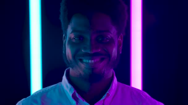 Портрет молодого афроамериканця, який дивиться на камеру і посміхається. Закрийся. Повільний рух. — стокове відео