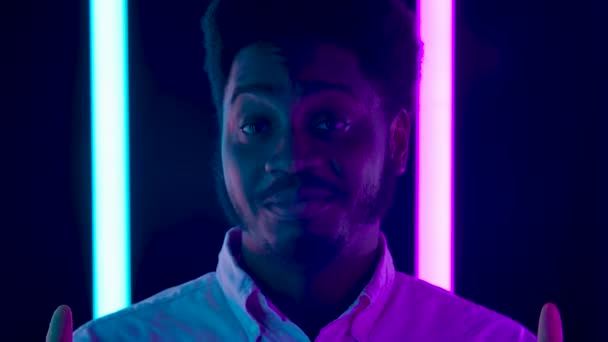 Portræt af en ung stilfuld mandlig afroamerikaner, der kigger på kamera smilende og viser tommelfingre op gestus. Tæt på. Langsom bevægelse. – Stock-video