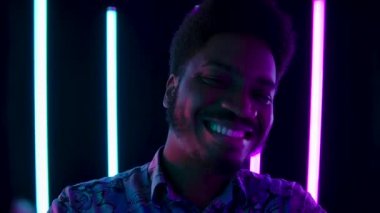 Kameraya bakarak şarkı söyleyen Afro-Amerikan bir gencin portresi. Ağır çekim. Kapat..