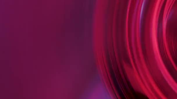Extreme Nahaufnahme einer transparenten Rolle mit Retro-Magnetband-Spins und dann in leuchtend rosa lila Neonlichter zurückspulen. Alte analoge Spule zu Spule Audio-Kassettenrekorder. Retro-Party. Zeitlupe. — Stockvideo