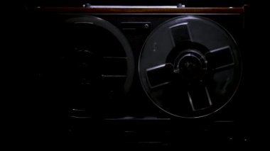 Karanlığın dokuma tezgahından kayıt cihazına kadar siyah bir stüdyonun arka planıyla. Retro analog müzik çalar. Ön taraf kapanıyor. Popüler disko trendleri 70 'ler, 80' ler. Yavaş çekim.