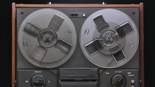 男性手操作老式卷轴,在黑色录音室背景下旋转磁带录音机.复古模拟音乐播放器。前视镜近视。流行的迪斯科趋势70，80年代。慢动作. — 图库视频影像