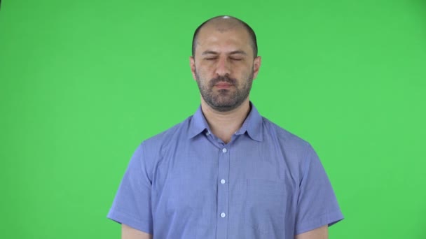 Ritratto di un uomo di mezza età che guarda la telecamera. Maschio calvo con la barba in camicia blu in posa su uno schermo verde in studio. Da vicino.. — Video Stock