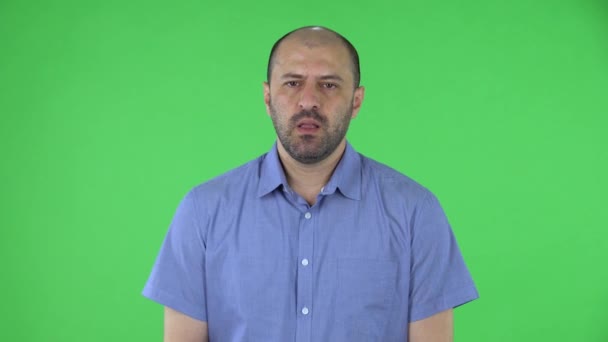 Portret mężczyzny w średnim wieku patrzącego w kamerę z podnieceniem i emocjami. Łysiejący mężczyzna z brodą w niebieskiej koszuli, pozujący w studio na zielonym ekranie. Zamknij się.. — Wideo stockowe