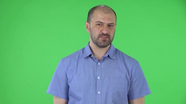 Portrait d'un homme d'âge moyen regardant la caméra penser avec concentration puis bouleversé aucune idée. Homme chauve avec barbe en chemise bleue posant sur écran vert en studio. Gros plan. — Video