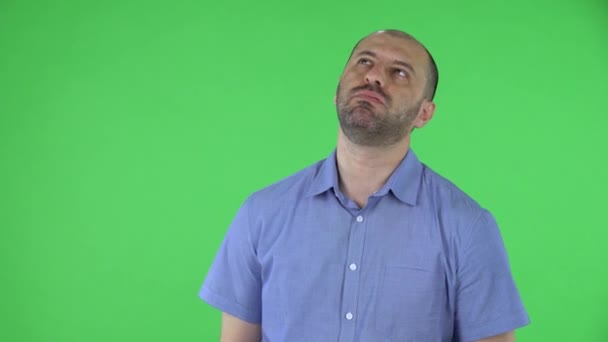 Portret mężczyzny w średnim wieku jest zdenerwowany i zmęczony. Łysiejący mężczyzna z brodą w niebieskiej koszuli, pozujący w studio na zielonym ekranie. Zamknij się.. — Wideo stockowe