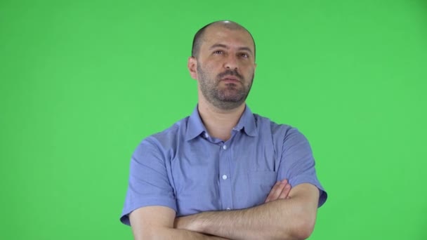 Portrait of a middle aged men looking at the camera telling interesting information and gesturing with his hands. Balding male with beard in blue shirt posing on green screen in the studio. Close up. — Stock Video