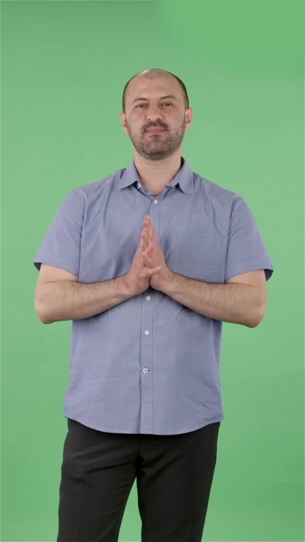 Портрет чоловіків середнього віку втомився. Оболонка чоловічої статі з бородою в синій сорочці позує на зеленому екрані в студії. Повільний рух. Вертикальне відео . — стокове відео