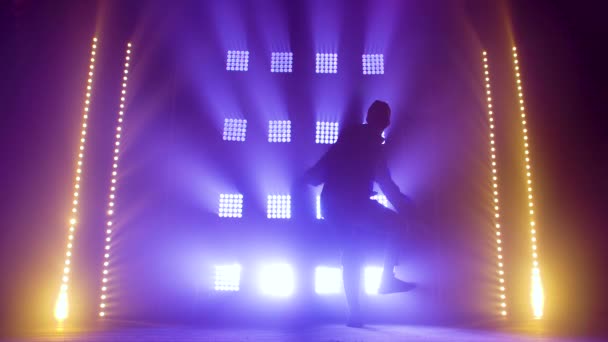 Silhouette di una giovane ballerina di talento di hip hop. Hip hop street dance su un palco in studio buio con fumo e luci al neon. Effetti dinamici della luce. Abilità creative. Rallentatore. — Video Stock