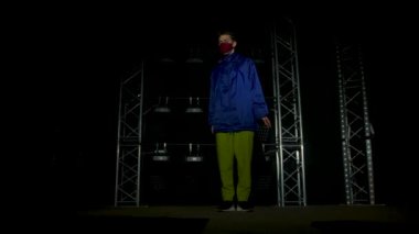 Yetenekli genç bir hip hop dansçısının silueti. Karanlık bir stüdyoda, dumanlı ve neon ışıklı bir sahnede hip hop sokak dansı. Dinamik ışıklandırma efektleri. Yaratıcı yetenekler. Yavaş çekim.