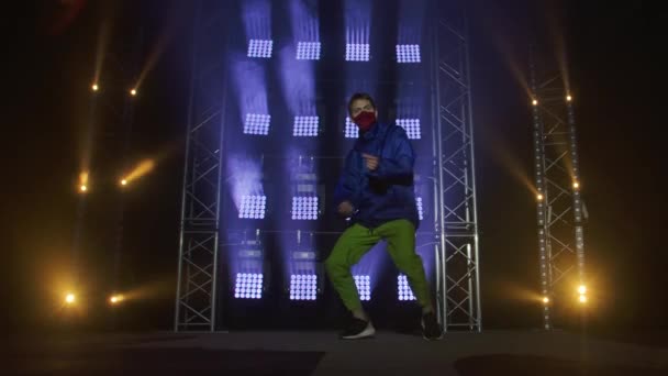 Silhouette d'un jeune danseur hip hop talentueux. Danse de rue hip hop sur une scène dans un studio sombre avec de la fumée et un éclairage au néon. Effet d'éclairage dynamique. Des talents créatifs. Mouvement lent. — Video