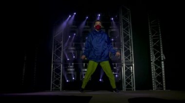 Yetenekli genç bir hip hop dansçısının silueti. Karanlık bir stüdyoda, dumanlı ve neon ışıklı bir sahnede hip hop sokak dansı. Dinamik ışıklandırma efektleri. Yaratıcı yetenekler. Yavaş çekim.