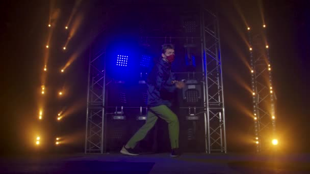Silhuett av en begåvad ung hip hop dansare. Hip hop street dance på en scen i mörk studio med rök och neonbelysning. Dynamiska ljuseffekter. Kreativa färdigheter. Långsamma rörelser. — Stockvideo