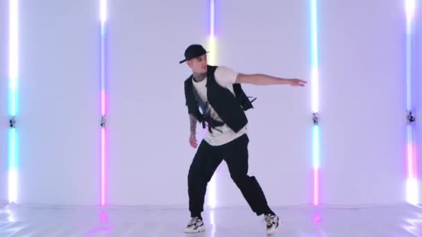 Professionelle Hip-Hop-Tänzerin übt Streetdance-Elemente gegen grelles Neonlicht im Studio. Stilvoller Mann tanzt energisch in Zeitlupe. — Stockvideo