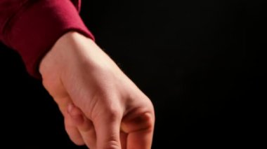Evde çikolatalı fondü. Erkek elleri erimiş siyah çikolataya daldırıyor. Çikolatalı şeker. Siyah arka planda izole edilmiş. Kapatın. Yavaş çekim.