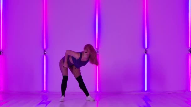 Sensual, sexy dancing young woman with pink hair in the studio. Slow motion female dancer dancing twerk, shaking her butt against the backdrop of bright neon lights. — Vídeo de stock