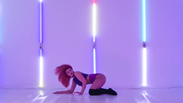 Side view attractive sexy woman in knee socks and shorts dancing twerk, shaking her ass. Sensual young dancer twerks her buttocks in the studio against the backdrop of bright neon lights. Slow motion. — Stock video