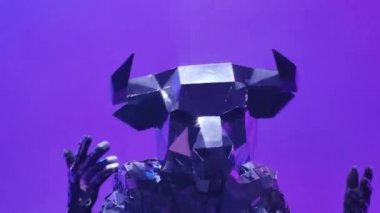 Neon mavisi pembe stüdyo arka planında dans eden aynalardan yapılmış kostümlü parlak gümüş boğa. 2021 'in sembolü, boğa, parlıyor ve siber disko partisinde kulüp ışıklarına yansıyor. Kapatın. Yavaş çekim.