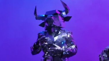 Aynalardan yapılmış iki parlak boğa neon mavisi pembe stüdyo arka planında dans ediyor. 2021 'in sembolü, boğa, parlıyor ve siber disko partisinde kulüp ışıklarına yansıyor. Kapatın. Yavaş çekim.