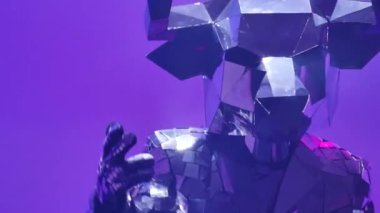 Neon mavisi pembe stüdyo arka planında dans eden aynalardan yapılmış kostümlü parlak gümüş boğa. 2021 'in sembolü, boğa, parlıyor ve siber disko partisinde kulüp ışıklarına yansıyor. Kapatın. Yavaş çekim.