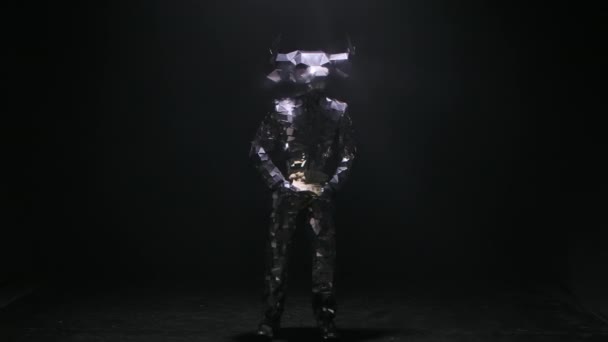 Showman in spiegelglattem Kostüm aus Spiegeln tanzt und streut fröhlich Dollars in einem dunkel verrauchten Studio. Schauspieler in Gestalt gehörnter, futuristisch leuchtender Stiere. Reicher Lebensspaß. Zeitlupe. — Stockvideo