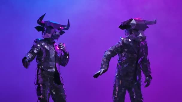 Zwei glänzende Stiere in Kostümen aus Spiegeln tanzen lustig auf neonblauem rosa Studiohintergrund. Symbol des Jahres 2021, Stier, leuchtet und spiegelt sich in Clubleuchten bei der Cyber-Disco-Party. Aus nächster Nähe. Zeitlupe. — Stockvideo