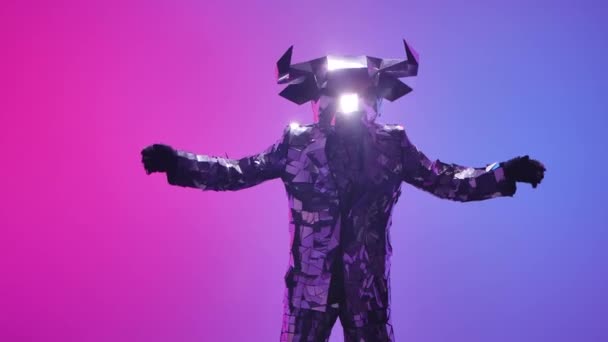 Brillante toro in costume fatto di specchi danza robot danza su sfondo al neon blu rosa studio. Simbolo del 2021, toro, brilla e si riflette nelle luci del club alla cyber disco party. Chiudete. Rallentatore. — Video Stock