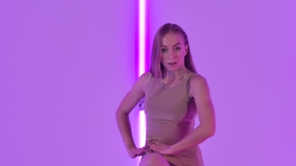 Feminina dansatoare efectuează dispreț senzual și sare grațios pe un fundal de lumini luminoase de neon. O tânără care dansează coregrafie modernă într-un studio întunecat. De aproape. Slow motion . — Videoclip de stoc