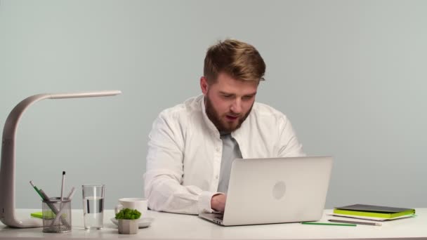 Jeune homme étudiant indépendant utilisant un ordinateur portable travaillant à partir du bureau à la maison. Travailleur à distance ou étudiant masculin étudiant en ligne, e-learning. Fatigué, ferme l'ordinateur portable. Ferme là. Mouvement lent. — Video