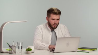 Genç adam bilgisayarda yazıyor, internette geziniyor, ekrana nefret ve tiksintiyle bakıyor. Merkez ofisteki yaratıcı adam uzaktan bilgisayarla çalışıyor. Kapatın. Yavaş çekim.