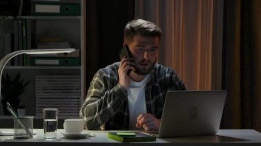Ofiste otururken bilgisayarla uzaktan çalışan pozitif sakallı bir adam. Freelancer işini yarıda kesiyor ve arkadaşça bir telefon görüşmesi yapıyor. Evden çalışmak için yeni bir kavram. Kapatın. Yavaş çekim.