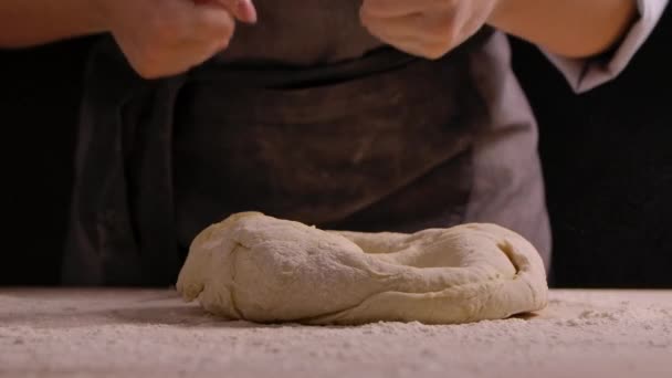Tangan wanita dipukul dengan tinjuan lutut adonan dalam tepung di atas meja. Proses membuat adonan buatan tangan dari tepung. Membuat roti, memasak kue dan manisan. Tutup, gerakan lambat. — Stok Video