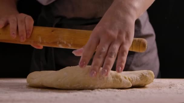 Vrouw handen rollen het deeg uit met een deegroller op keukentafel. Proces van het koken van zelfgemaakt deeg. Stappen koken bakken en snoep. Sluit maar af. Langzame beweging. — Stockvideo