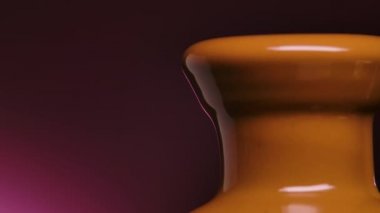 Sıvı çikolata akışı. Mor arka planda erimiş sıcak sütlü çikolata çeşmeleri. Ağır çekimde akan sıvı sıcak çikolataya yakın çekim.