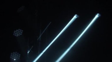 Dinamik beyaz ışınlar lazer hologramları ve spot ışıkları boş bir karanlık sahneyi aydınlatır. Projektör döner ve göz kırpar. Hologramları göster. Tatiller ve partiler için ışıklandırma ekipmanı ve efektleri. Kapat..