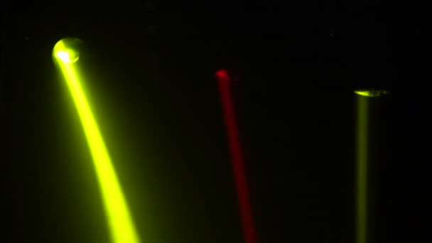 Luzes laser coloridas no palco. Spotlights gira, gira e emite feixes de luz vermelha e amarela no estúdio de fumaça escura. Mostra de hologramas. Luzes equipamentos e efeitos para feriados e festas. Fechar. — Vídeo de Stock